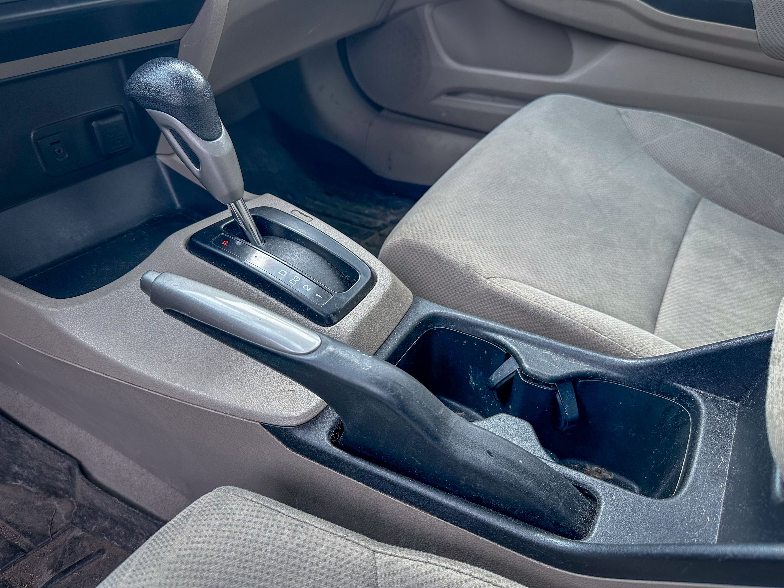 A photo of the center console of the Honda Civic, showing the parking brake in its off position