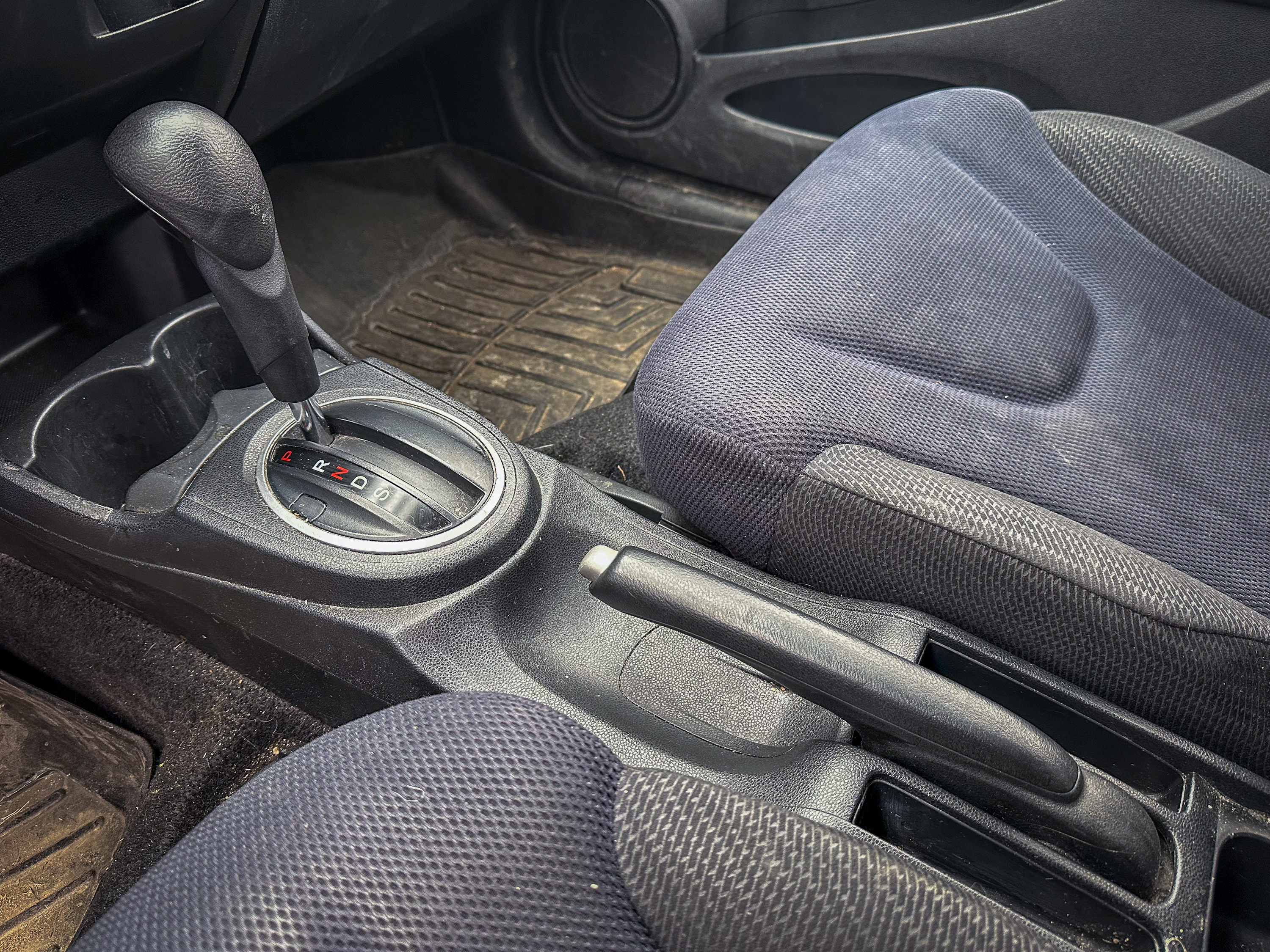 A photo of the center console of the Honda Fit, showing the parking brake in its off position