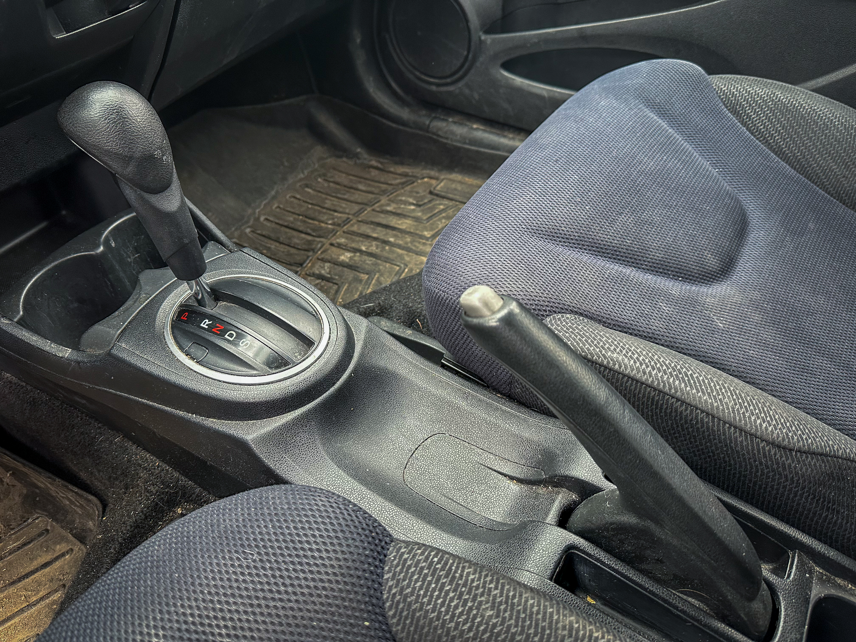 A photo of the center console of the Honda Fit, showing the parking brake in its on position