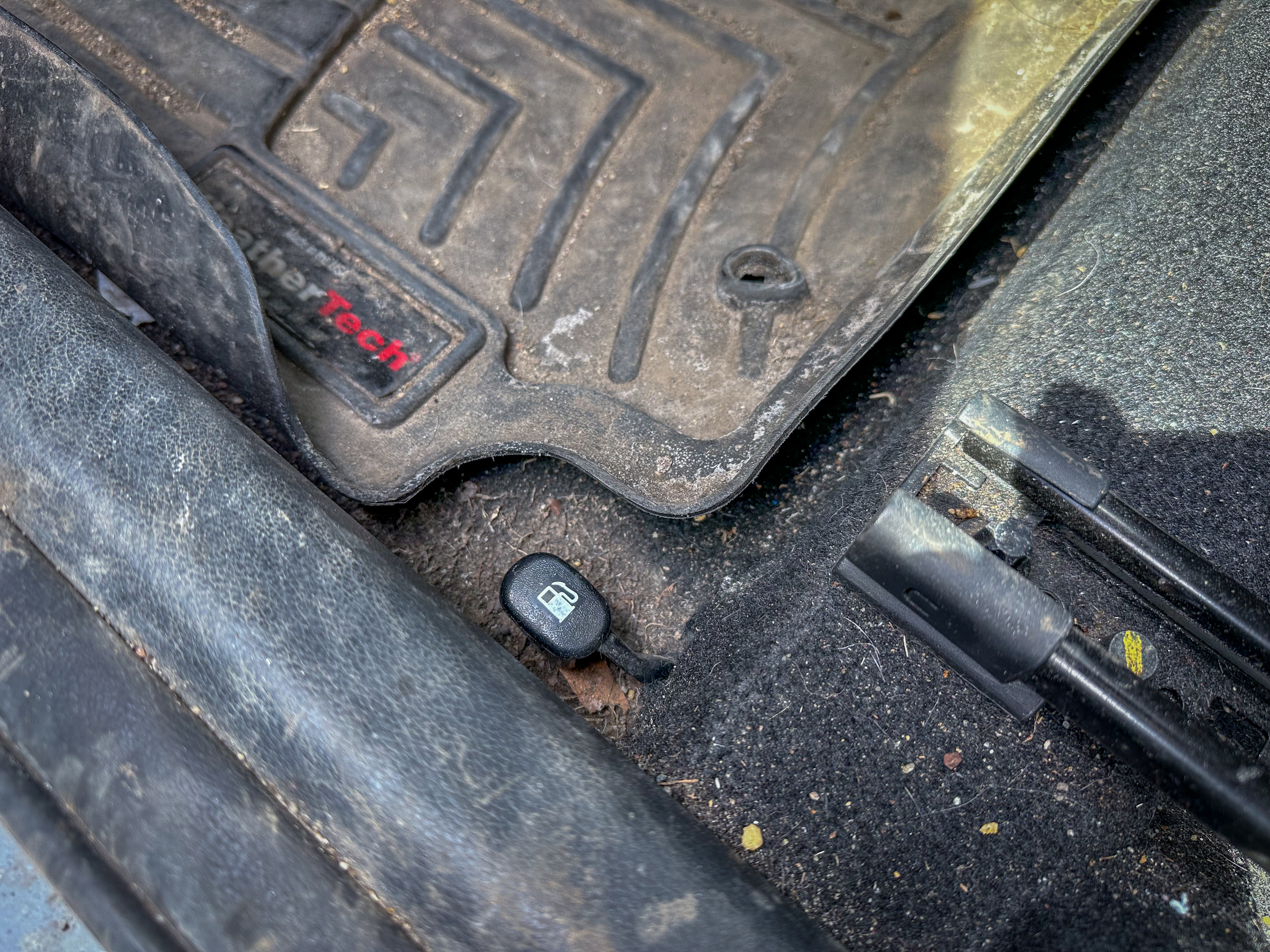 A photo of the Hyundai Kona fuel door latch, located on the driver's side floor