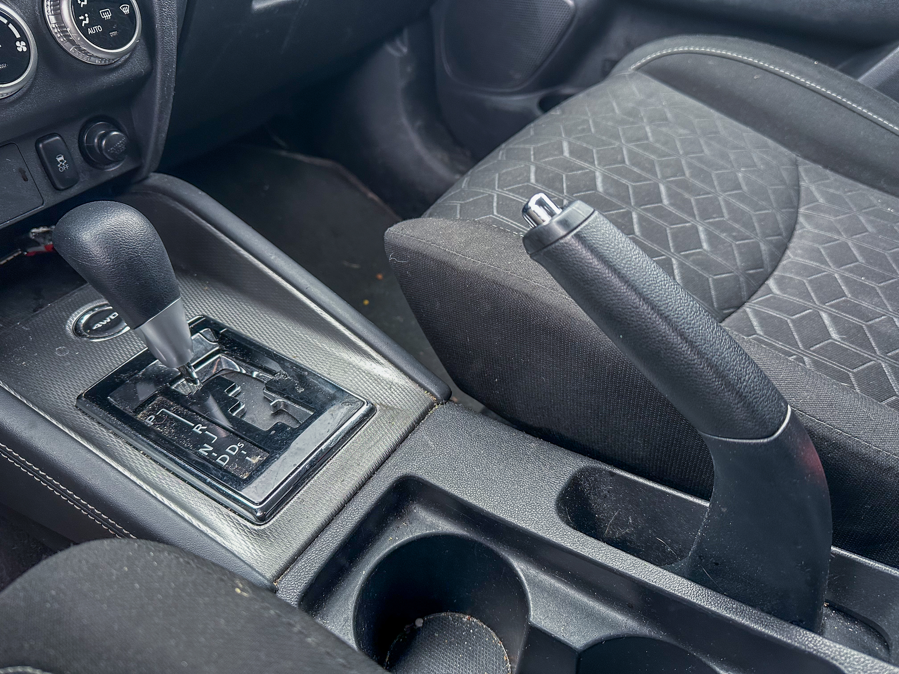 A photo of the Mitsubishi Outlander Sport parking brake lever in its on position, located in the center console